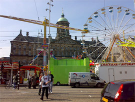A Ferris wheel and fair rides set up in front of the Royal Palace