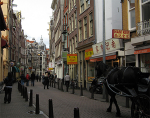 The Zeedijk street with Chinese restaurant signs and a horse-drawn carriage