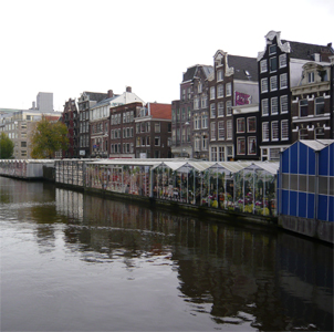 Canal houses and the back of the flower market stalls reflected in the Singel